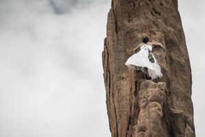 woman climbing steep rock